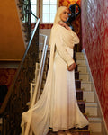 Robe longue drapée blanche cassé LUMYRA portée sur mannequin, tissu fluide et élégance sophistiquée.