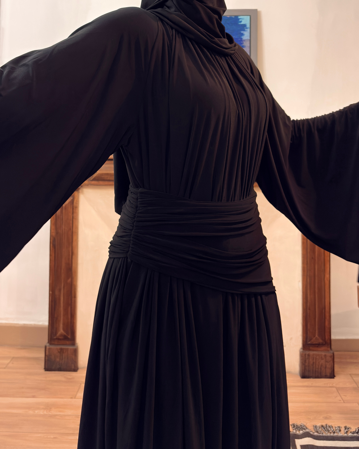 Robe longue noire à manches drapées de marque LUMYRA, vue en détail avec tissu fluide et élégance.